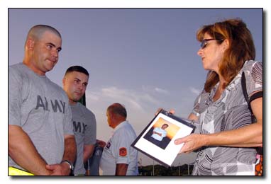 Elizabeth Berry shows soldiers from the 189th Military Police Co. at U.S. Naval Station Guantanamo Bay, July 15, 2009, a photograph of her brother, Capt. William F. Burke Jr., a firefighter from Engine 21 who died when the north tower of the World Trade Center collapsed. Berry and her sister, Janet Roy, were part of a group of Sept. 11, 2001, victim family members who asked to meet the Joint Task Force guards -- just to say, “thank you” -- when the group was here for the recent military commissions proceedings.
