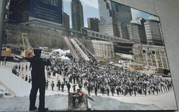 A police officer plays Taps in The Pit at the WTC's Ground Zero on the 1st anniversary of 9/11.